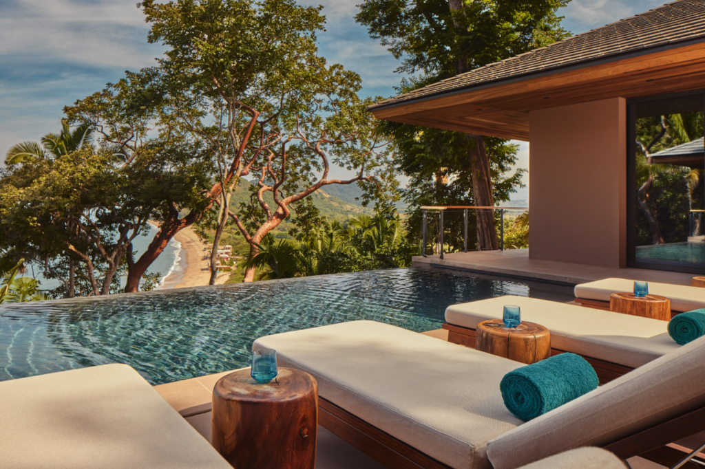 pool lounge chairs point towards ocean view