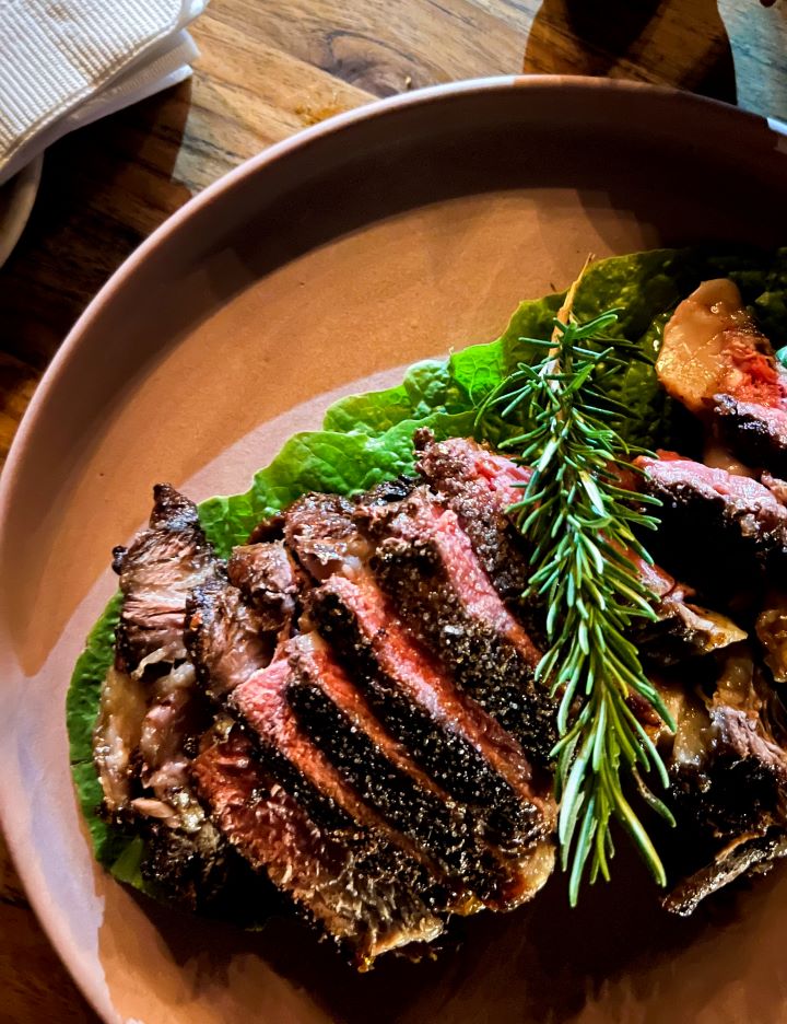 grilled steak cut finely on wood platter